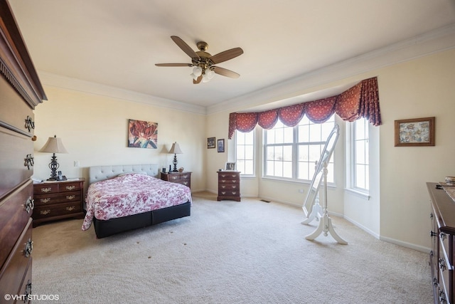 carpeted bedroom featuring baseboards, ornamental molding, and ceiling fan