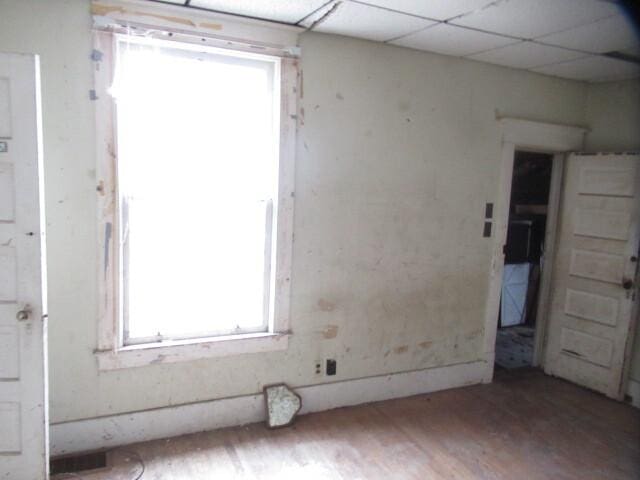 empty room featuring a paneled ceiling and wood finished floors