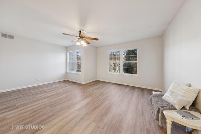 interior space featuring visible vents, ceiling fan, baseboards, and light wood-style floors