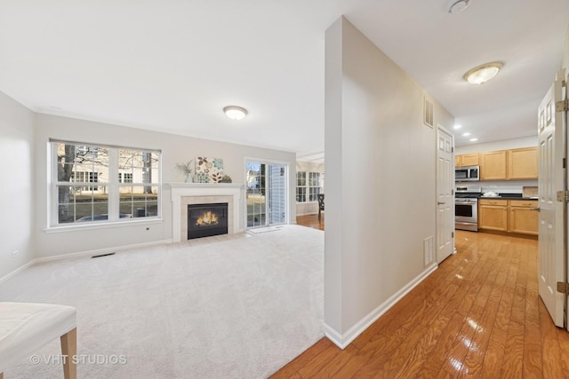 corridor featuring light wood-style flooring, visible vents, and baseboards