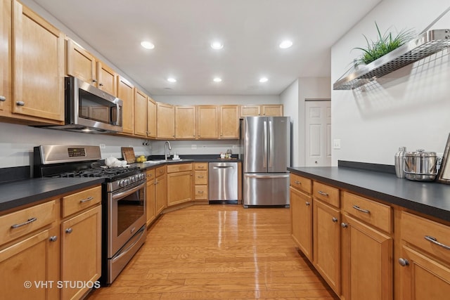 kitchen featuring dark countertops, appliances with stainless steel finishes, and a sink