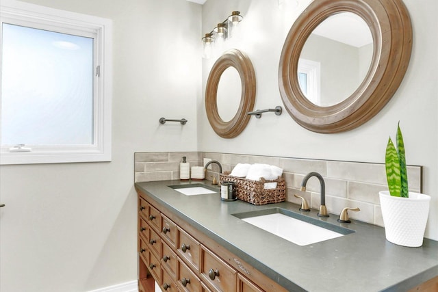 bathroom with a sink, backsplash, and double vanity