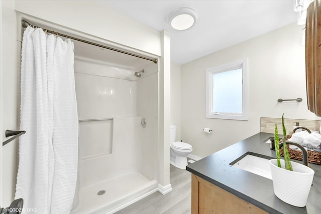 full bathroom with baseboards, toilet, wood finished floors, curtained shower, and vanity