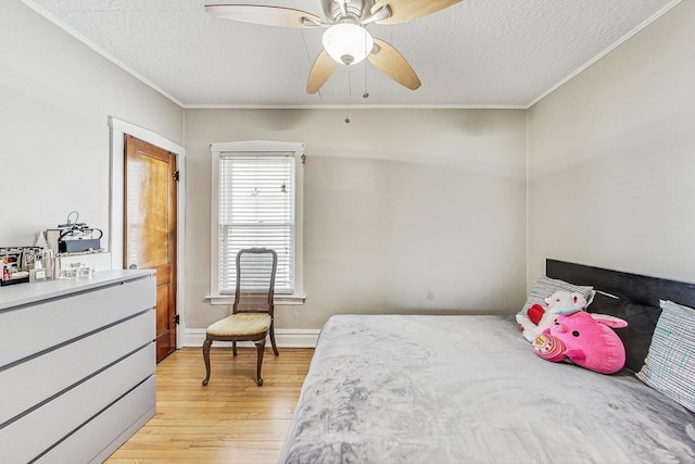 bedroom featuring a textured ceiling, baseboards, light wood-style flooring, and crown molding