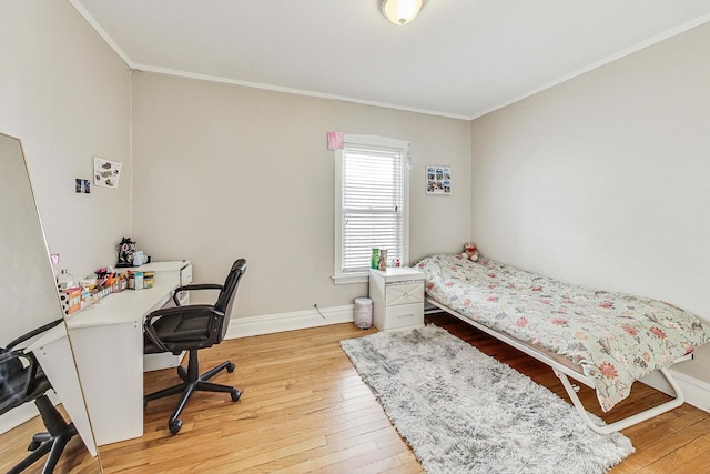 bedroom with ornamental molding, hardwood / wood-style flooring, and baseboards