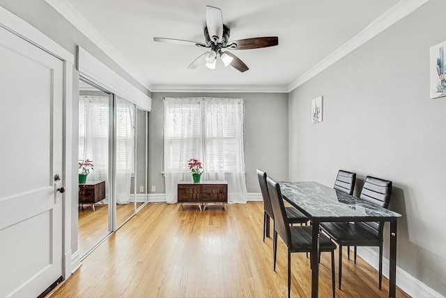 dining area with ceiling fan, ornamental molding, light wood-style flooring, and baseboards