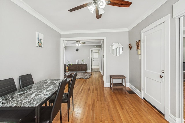 dining room featuring baseboards, ceiling fan, light wood-style flooring, and crown molding