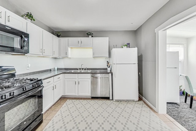 kitchen featuring dark countertops, black appliances, white cabinets, and a sink