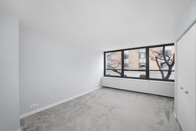 carpeted empty room featuring baseboards