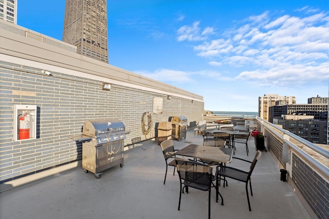 view of patio with a view of city, grilling area, and a balcony