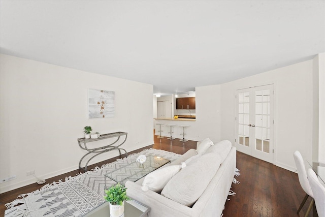 living area featuring baseboards, dark wood finished floors, and french doors