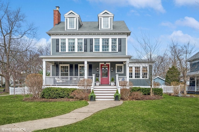 view of front of house featuring a porch, a front yard, fence, and a chimney