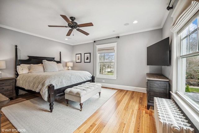 bedroom with light wood-type flooring, radiator, multiple windows, and baseboards