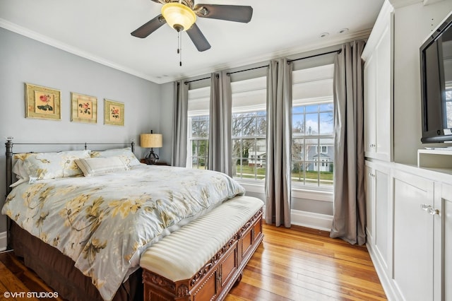 bedroom with baseboards, ornamental molding, light wood-style flooring, and a ceiling fan