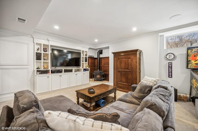 living area featuring a wood stove, visible vents, crown molding, and recessed lighting