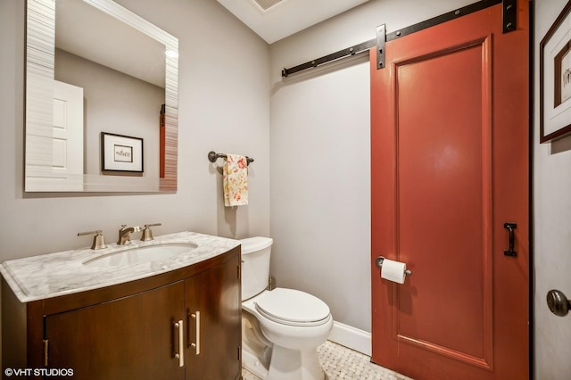 half bath with baseboards, vanity, and toilet