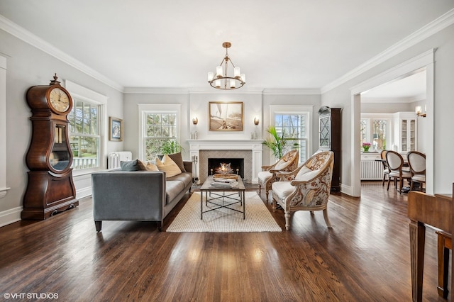 living area featuring a wealth of natural light, wood finished floors, and an inviting chandelier