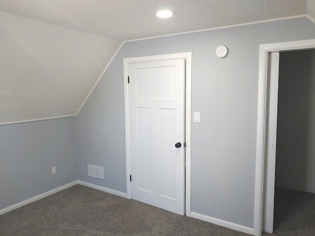 bonus room with lofted ceiling, baseboards, visible vents, and dark colored carpet