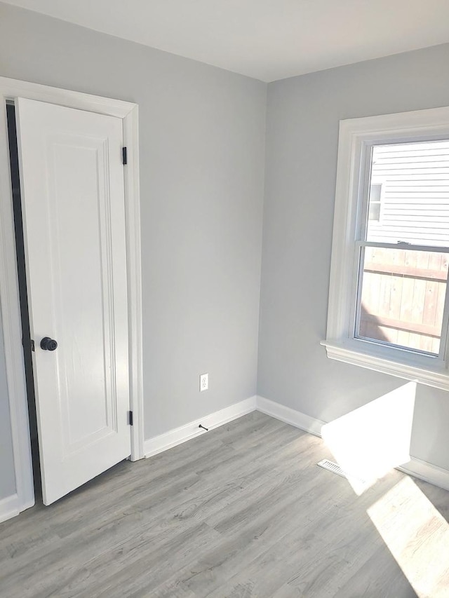 spare room featuring baseboards and wood finished floors