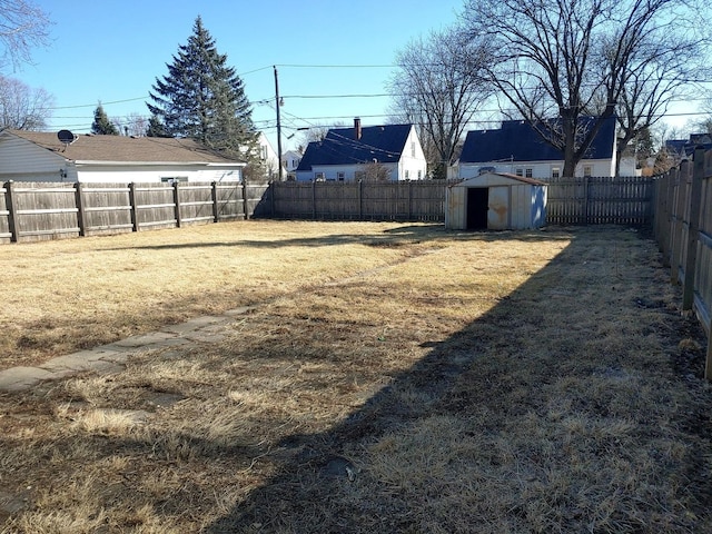 view of yard with an outbuilding, a storage shed, and a fenced backyard