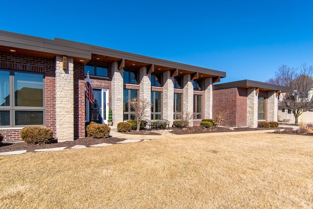 exterior space featuring a front lawn and brick siding