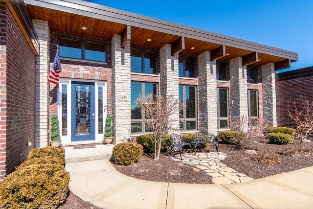 entrance to property featuring brick siding