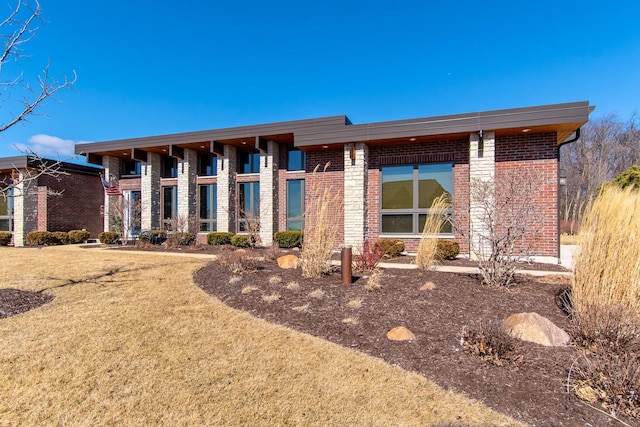 view of front of property featuring brick siding and a front lawn