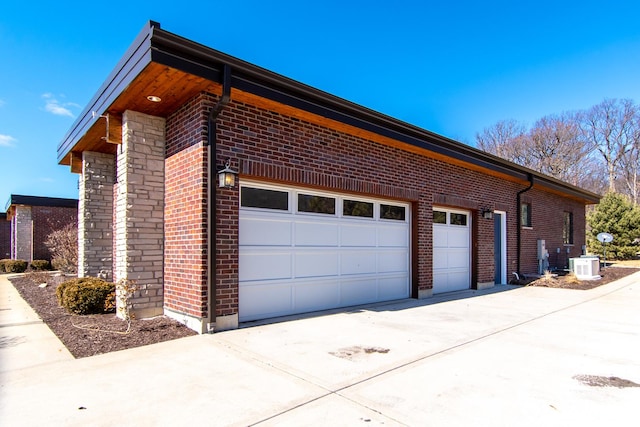 view of side of property featuring brick siding, driveway, and a garage