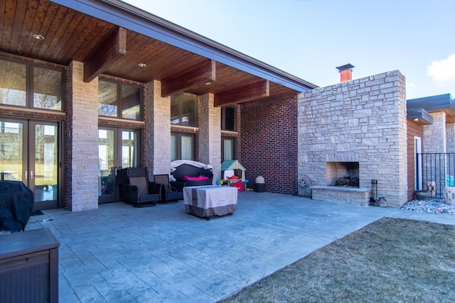 view of patio featuring an outdoor living space with a fireplace, grilling area, and french doors