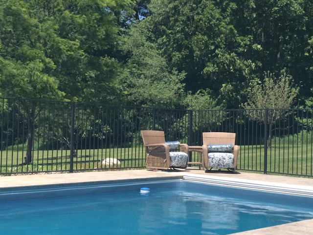 view of swimming pool featuring fence