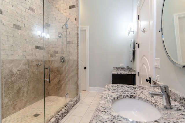 full bath featuring a shower stall, vanity, marble finish floor, and baseboards