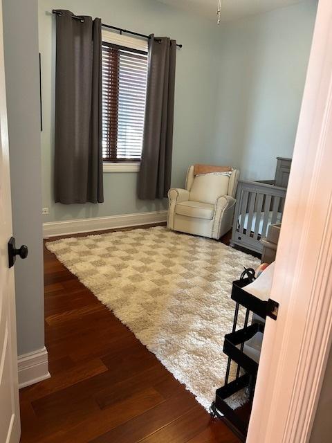 bedroom with baseboards and wood finished floors