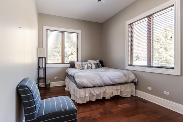 bedroom with visible vents, wood finished floors, and baseboards