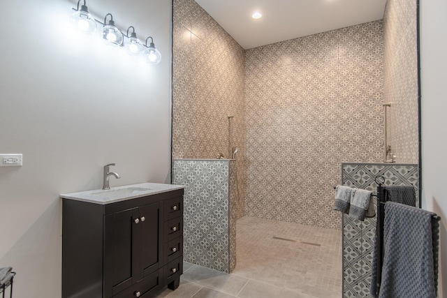 bathroom with tile patterned floors, a walk in shower, and vanity