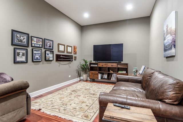 living area with baseboards and wood finished floors