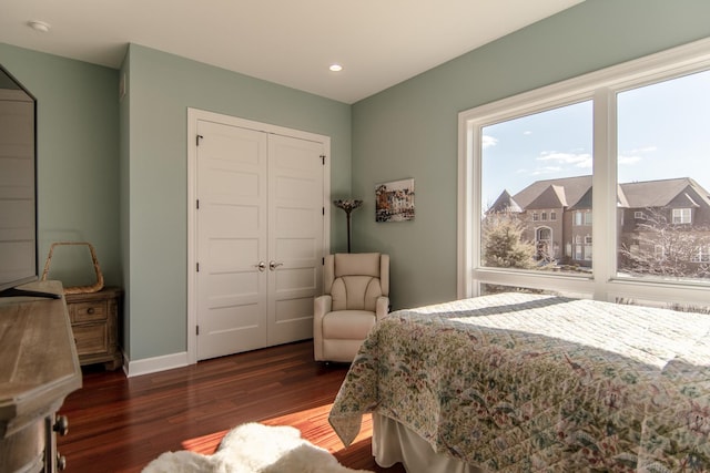 bedroom with recessed lighting, wood finished floors, a closet, and baseboards