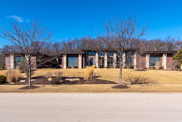 view of front of house featuring brick siding and a front yard