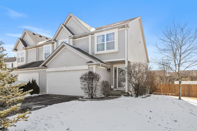 view of front of house with a garage, driveway, and fence