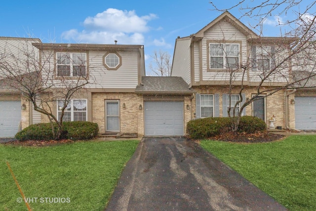 view of front of home with a garage, driveway, brick siding, and a front yard