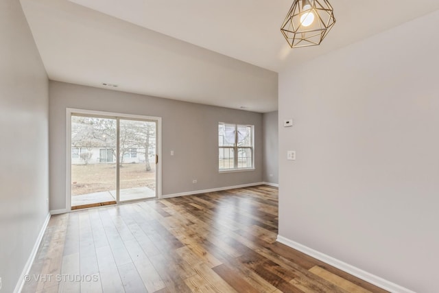 empty room with baseboards and wood finished floors