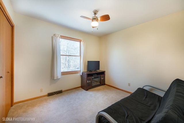 interior space with light colored carpet, visible vents, ceiling fan, and baseboards