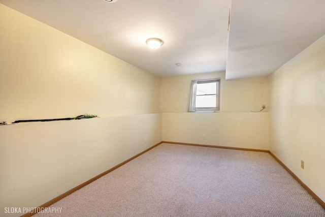 spare room with light carpet and baseboards