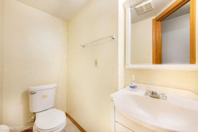 half bathroom with baseboards, visible vents, toilet, tile patterned floors, and vanity