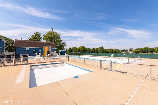 community pool featuring a patio and fence