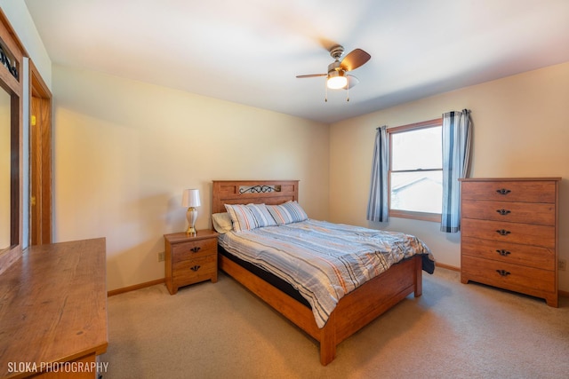 bedroom with light carpet, a ceiling fan, and baseboards