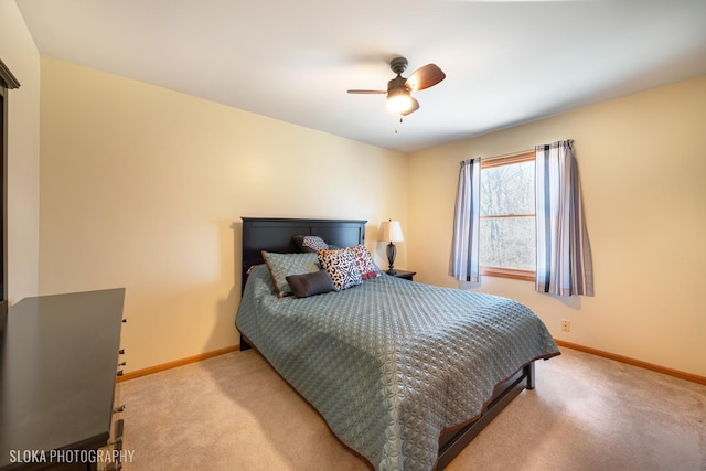 carpeted bedroom with ceiling fan and baseboards