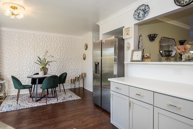 kitchen featuring wallpapered walls, dark wood-style floors, an inviting chandelier, crown molding, and stainless steel refrigerator with ice dispenser