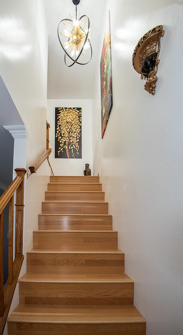 stairs with a chandelier