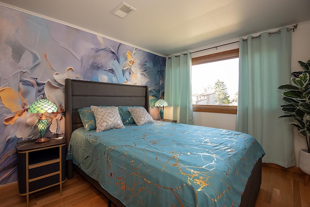 bedroom with visible vents and wood finished floors