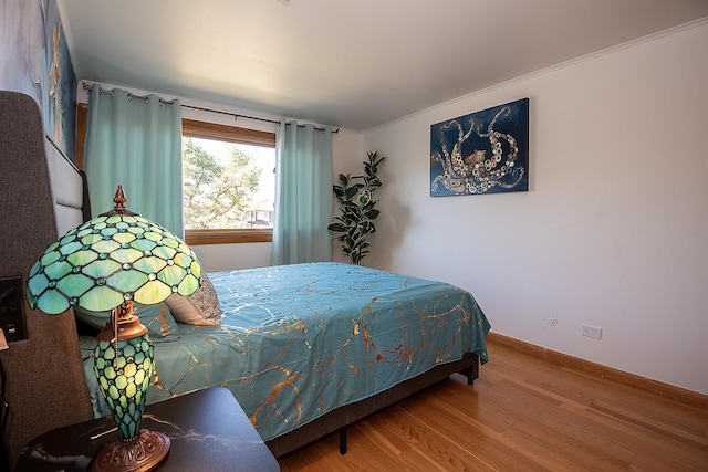 bedroom featuring baseboards and wood finished floors